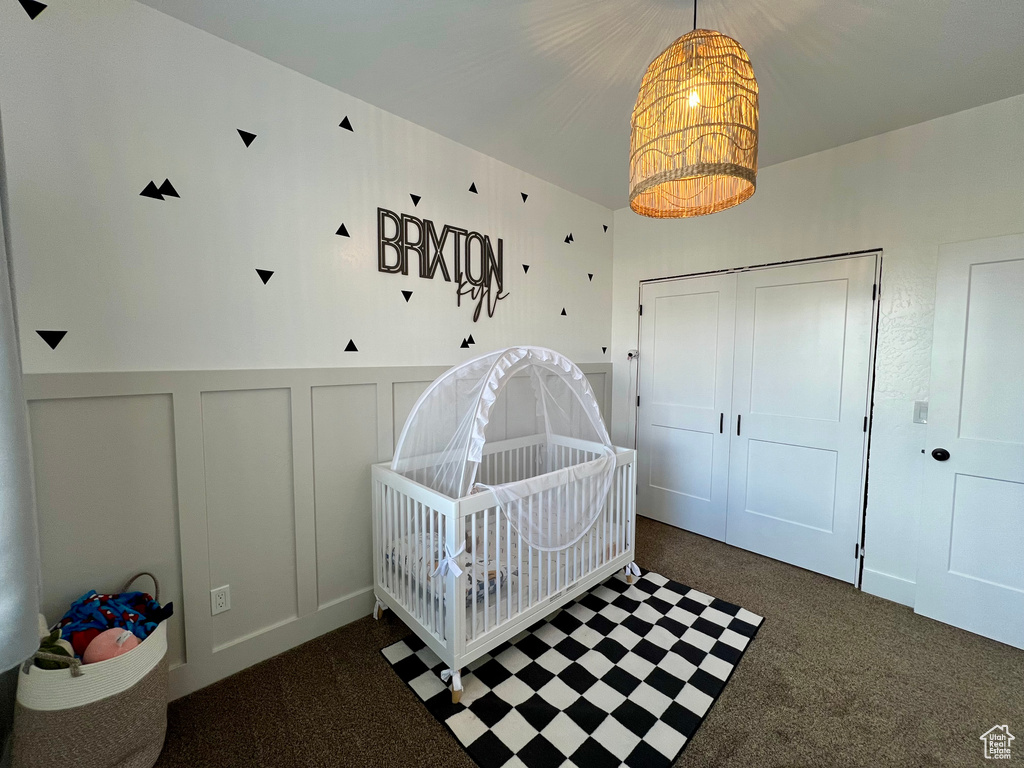 Carpeted bedroom featuring a crib