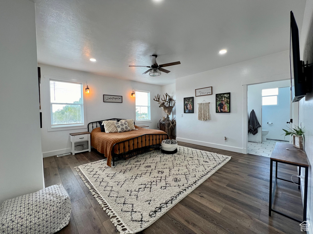 Bedroom with dark wood-type flooring, ceiling fan, and ensuite bath