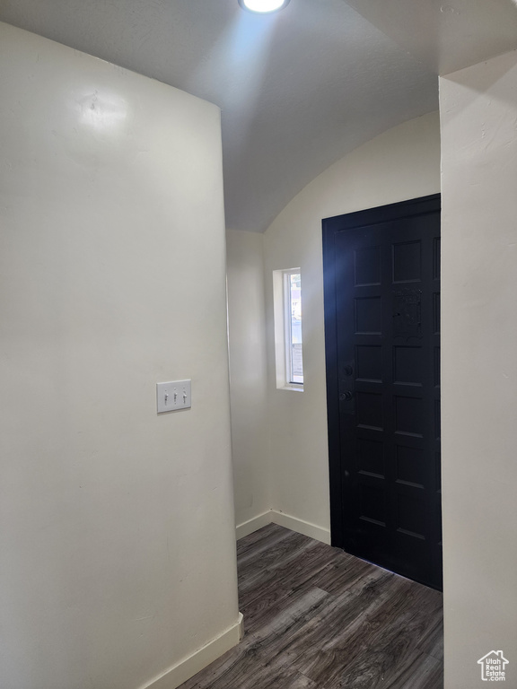 Foyer featuring dark hardwood / wood-style floors and lofted ceiling