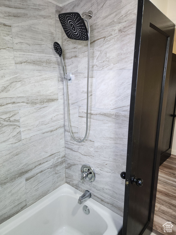 Bathroom featuring tiled shower / bath and wood-type flooring