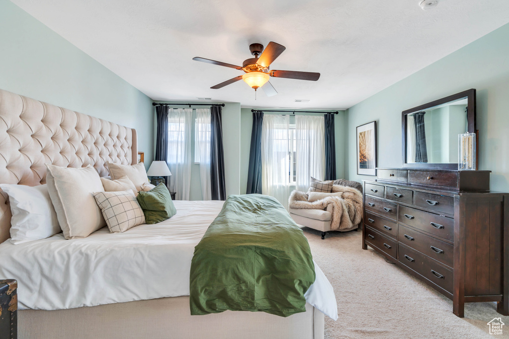 Bedroom with ceiling fan and light carpet