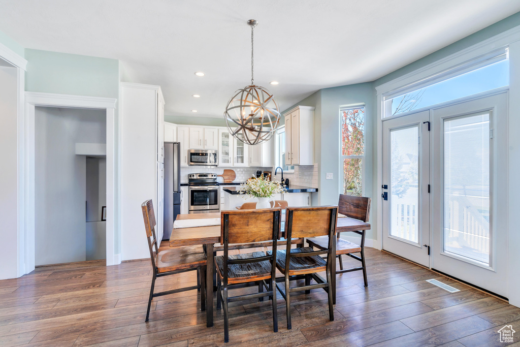 Dining room featuring sink, an inviting chandelier, and dark hardwood / wood-style floors