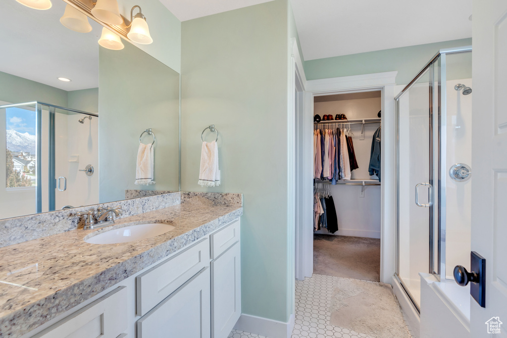 Bathroom with vanity, tile patterned flooring, and a shower with shower door