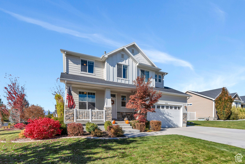 Craftsman-style house featuring a garage, a porch, and a front yard