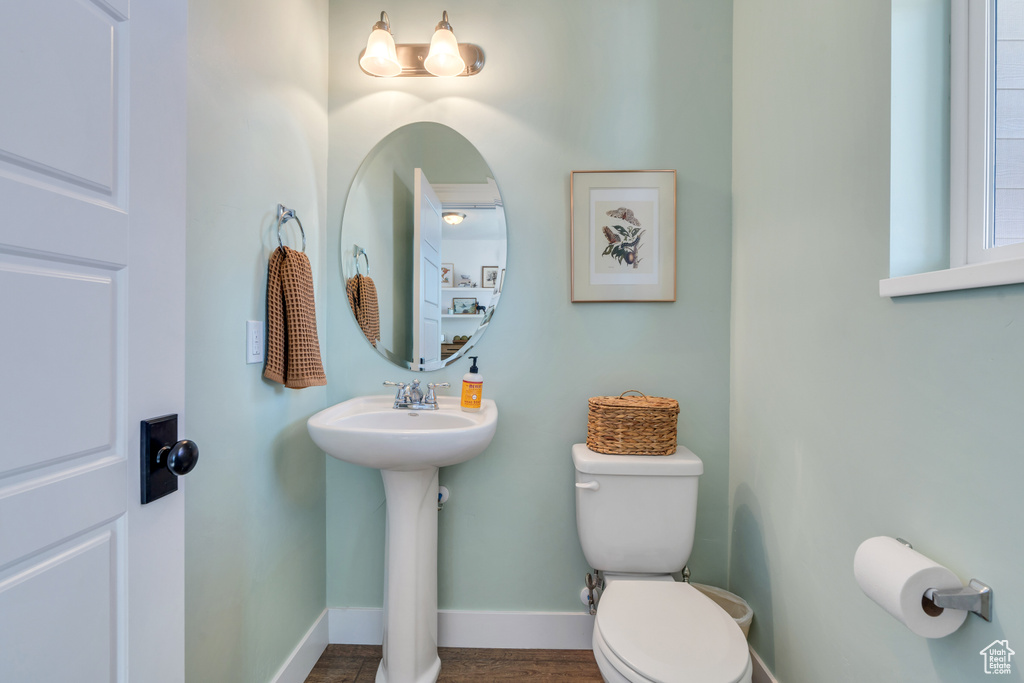 Bathroom with wood-type flooring, sink, and toilet