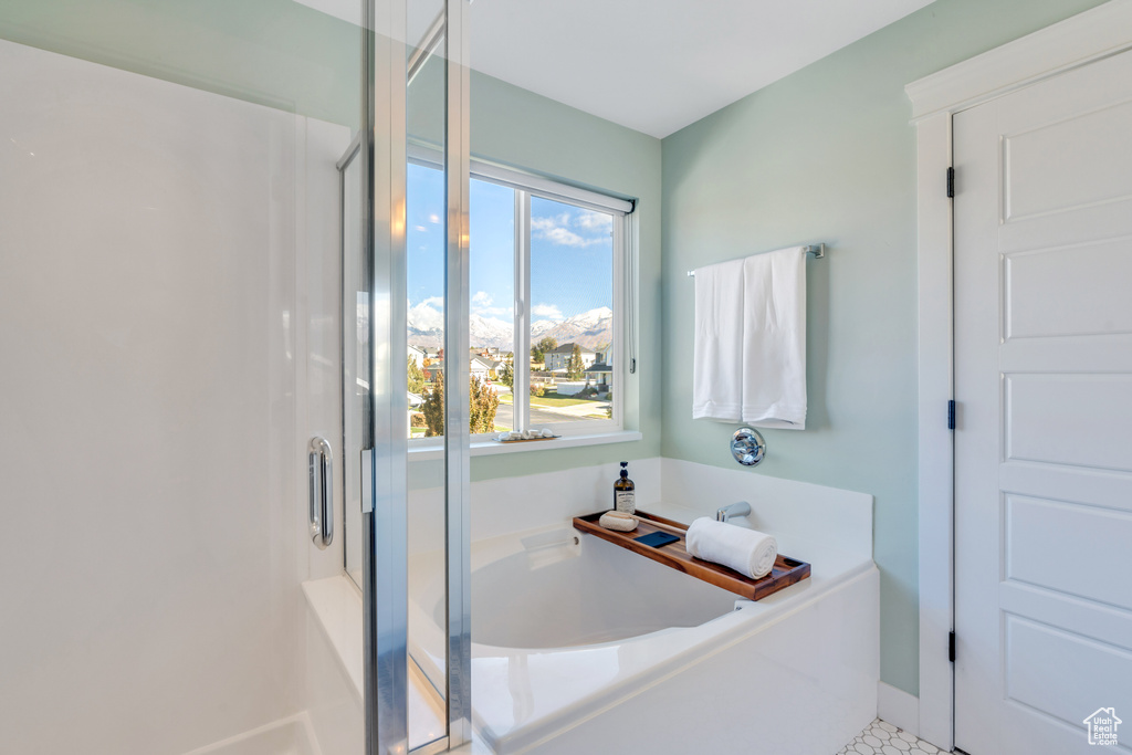 Bathroom featuring a tub to relax in and tile patterned flooring