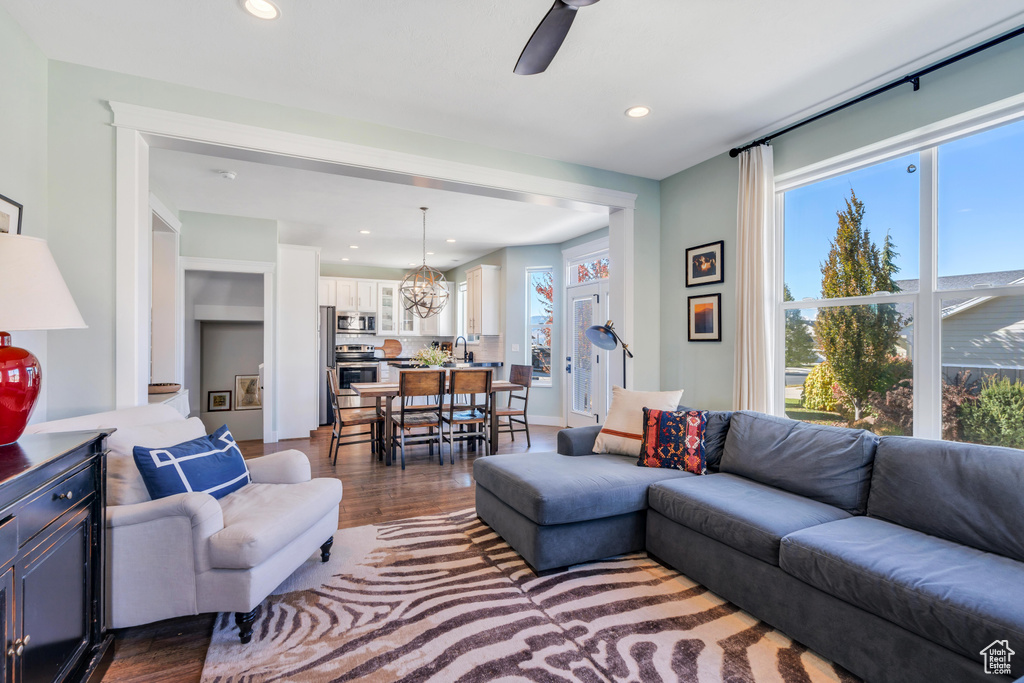 Living room with a wealth of natural light, ceiling fan, sink, and dark hardwood / wood-style flooring