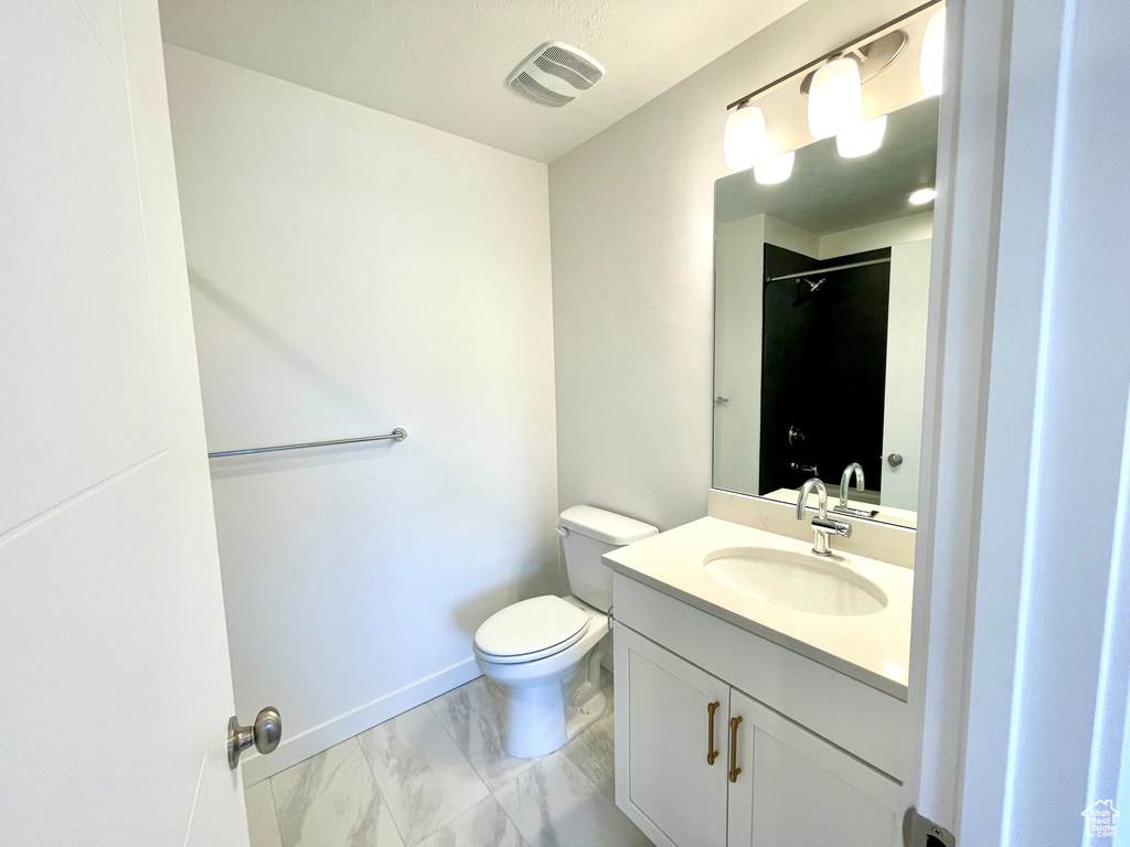 Full bathroom featuring marble finish flooring, vanity, and a shower
