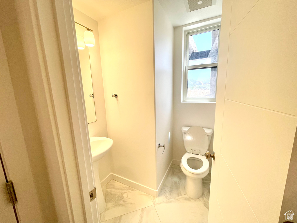 Bathroom with marble finish floors and toilet