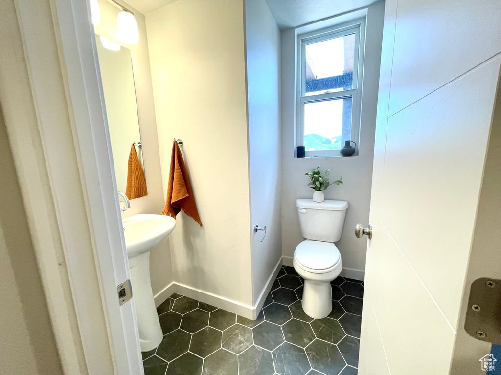 Half bath featuring toilet and tile patterned floors