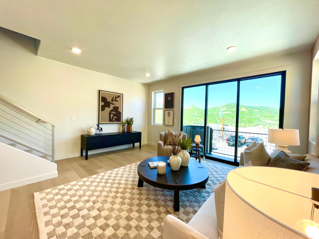 Living room with wood finished floors, stairway, and recessed lighting