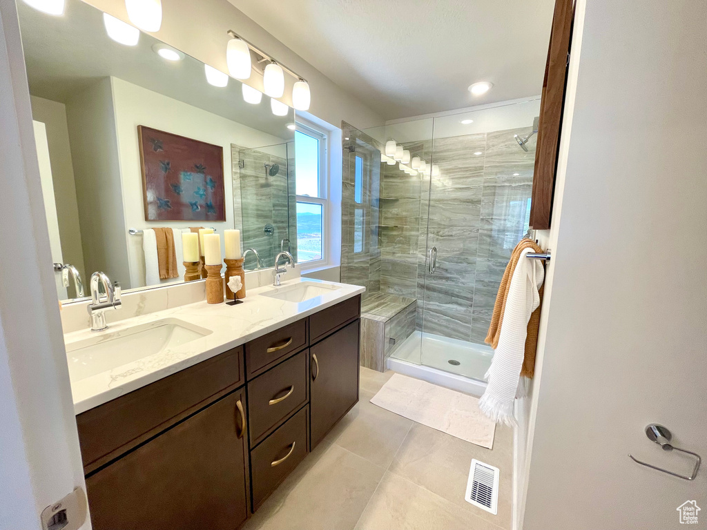 Full bathroom with tile patterned floors, a stall shower, and double vanity