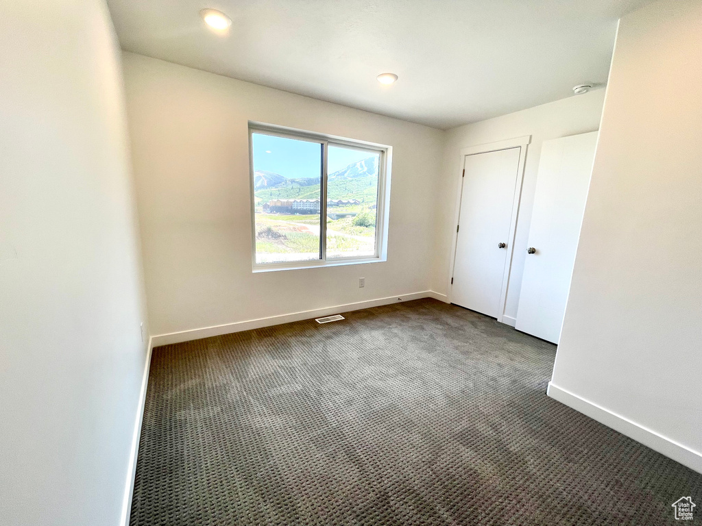 Unfurnished bedroom featuring dark carpet and recessed lighting