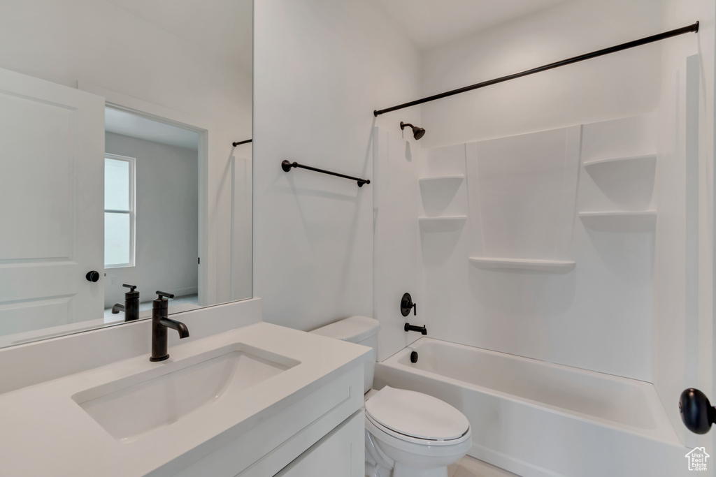 Bathroom featuring shower / bath combination, vanity, and toilet