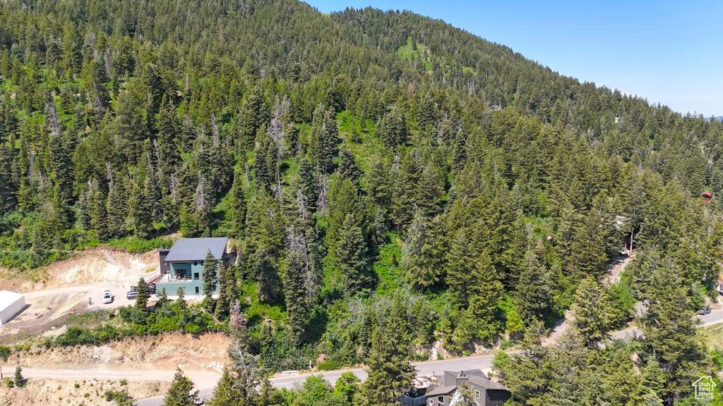 Aerial view of property and surrounding area with a heavily wooded area
