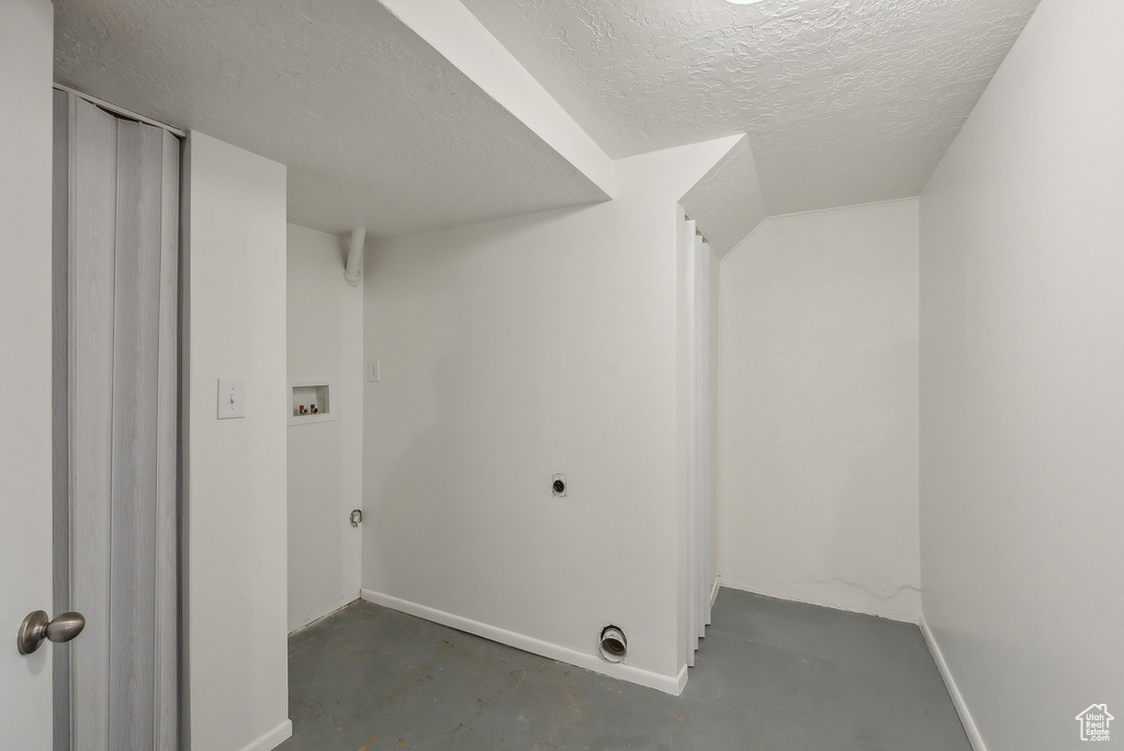 Laundry room featuring hookup for an electric dryer, a textured ceiling, and hookup for a washing machine