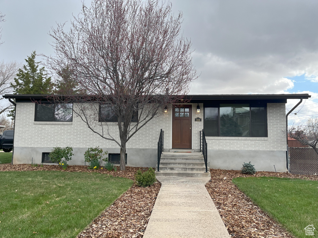 View of front facade with a front lawn and brick siding