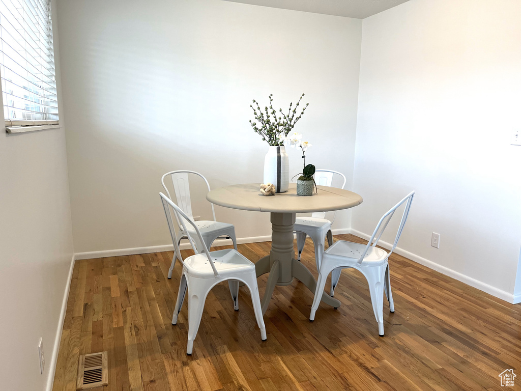 Dining room with wood finished floors, baseboards, and visible vents