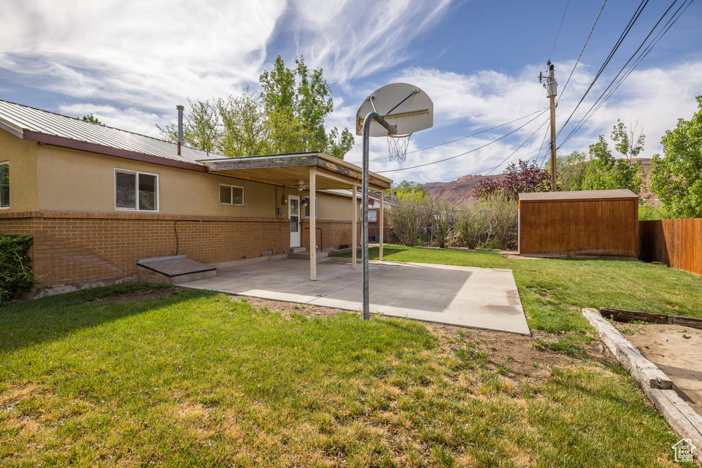 View of yard featuring an outdoor structure, a patio, fence, and a mountain view