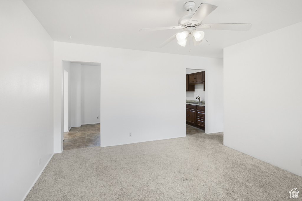 Spare room with light carpet, a sink, and ceiling fan