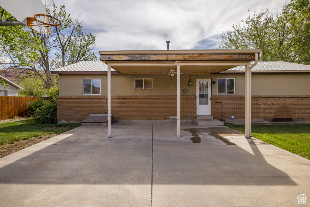 View of front of home with metal roof, fence, brick siding, entry steps, and stucco siding