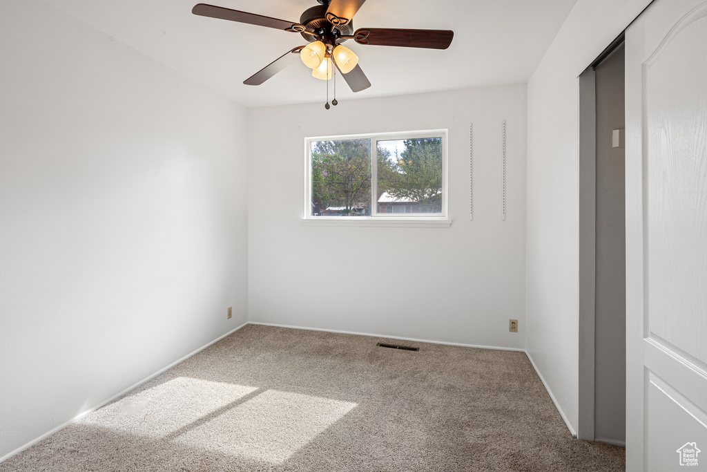 Unfurnished bedroom with visible vents, a ceiling fan, carpet flooring, and baseboards