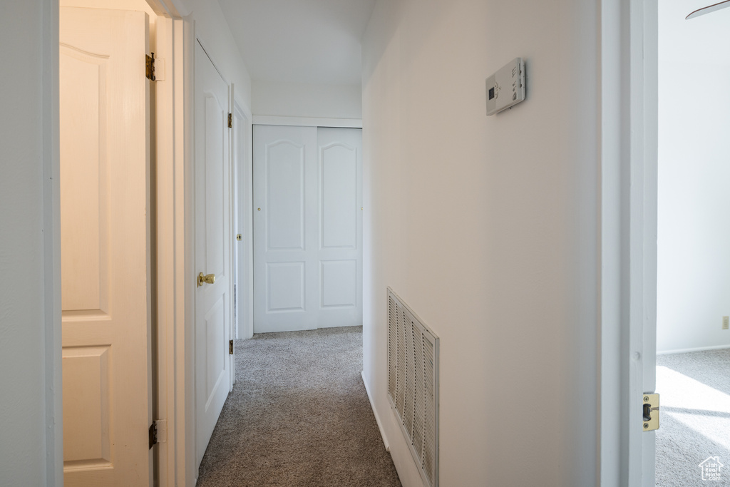 Hall with carpet flooring and visible vents