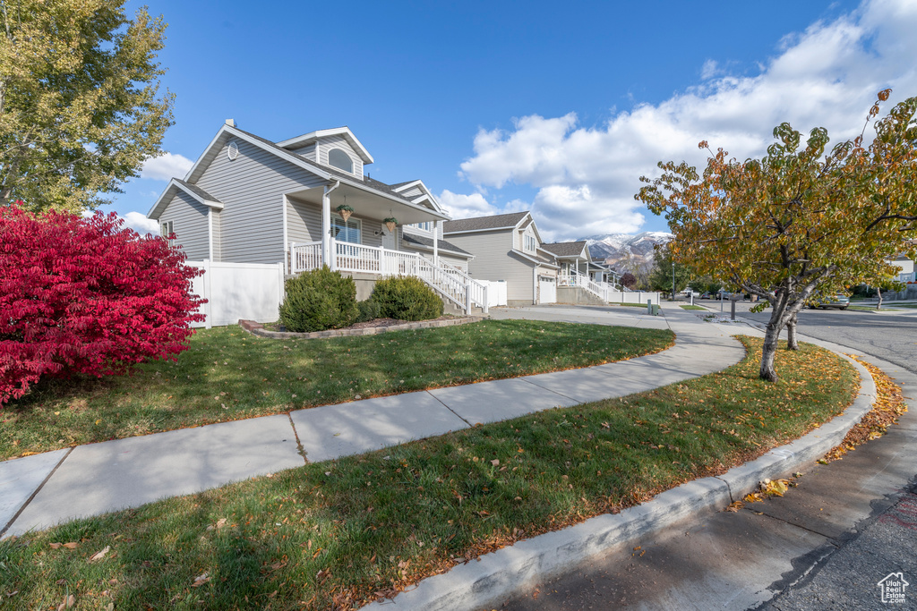 View of property exterior with a lawn and a porch