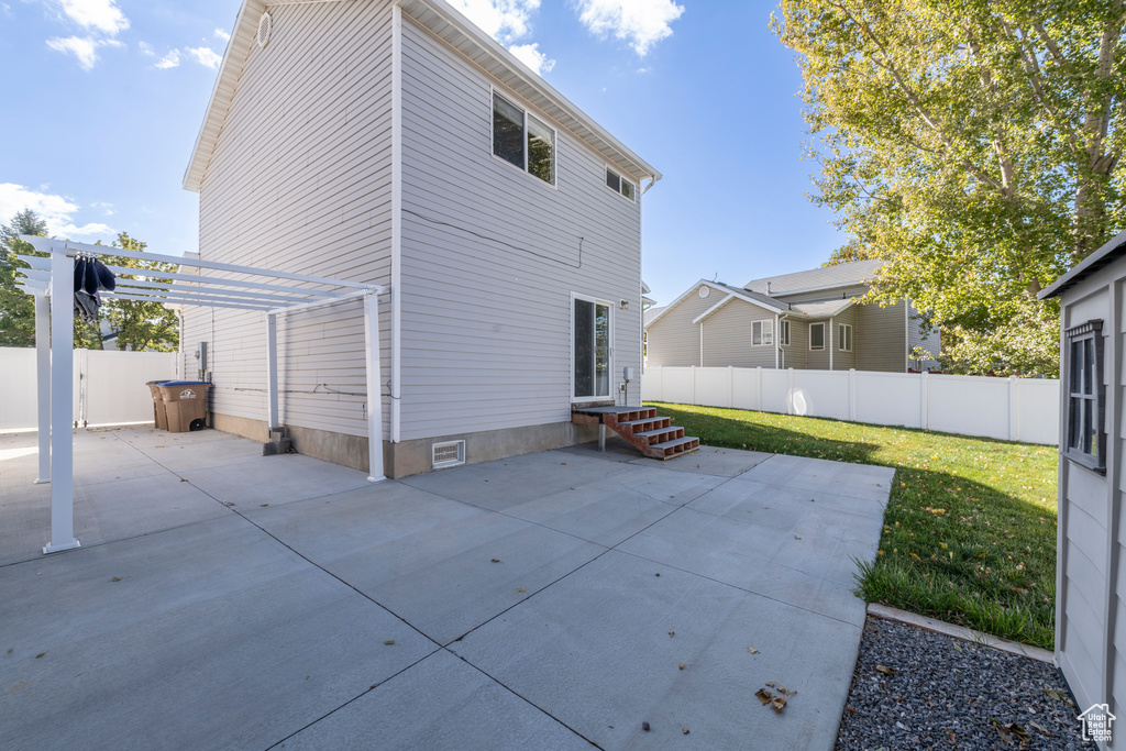 Rear view of house with a yard, a pergola, and a patio area