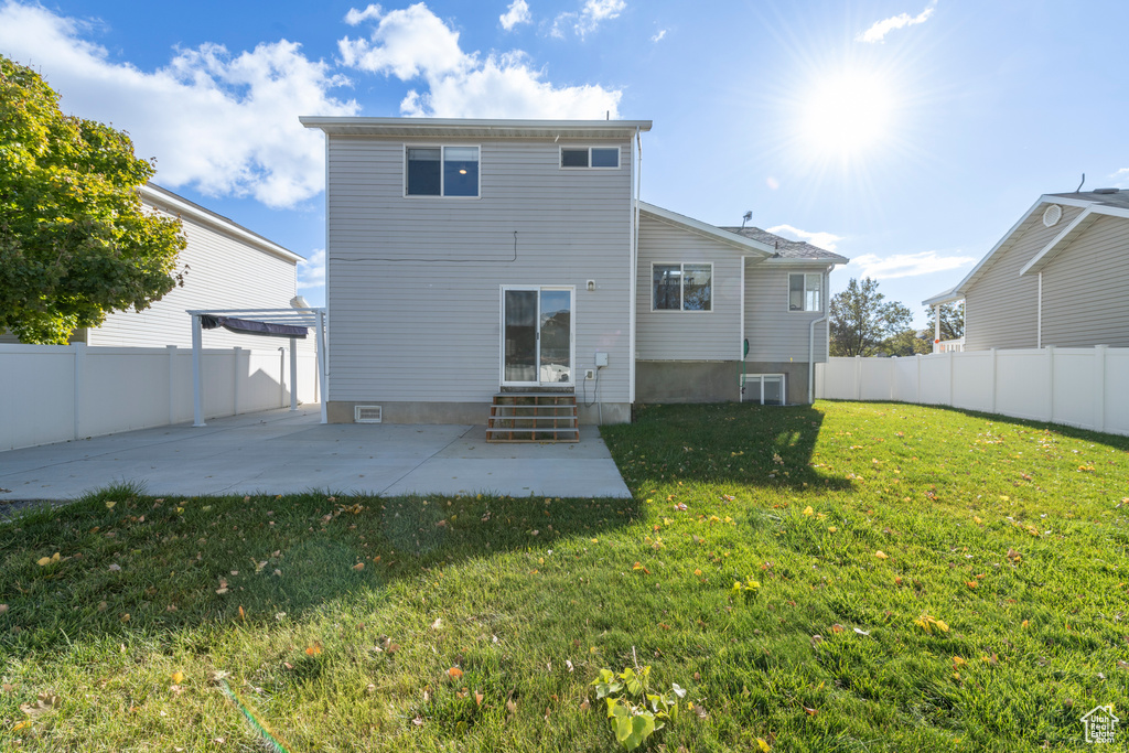 Back of property featuring central AC, a lawn, and a patio