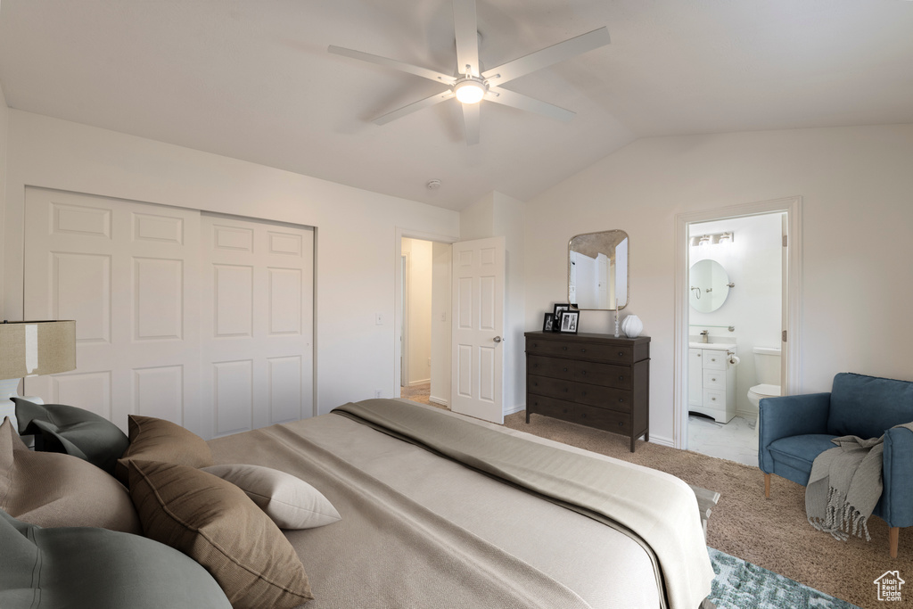 Bedroom with a closet, lofted ceiling, light colored carpet, ceiling fan, and ensuite bathroom