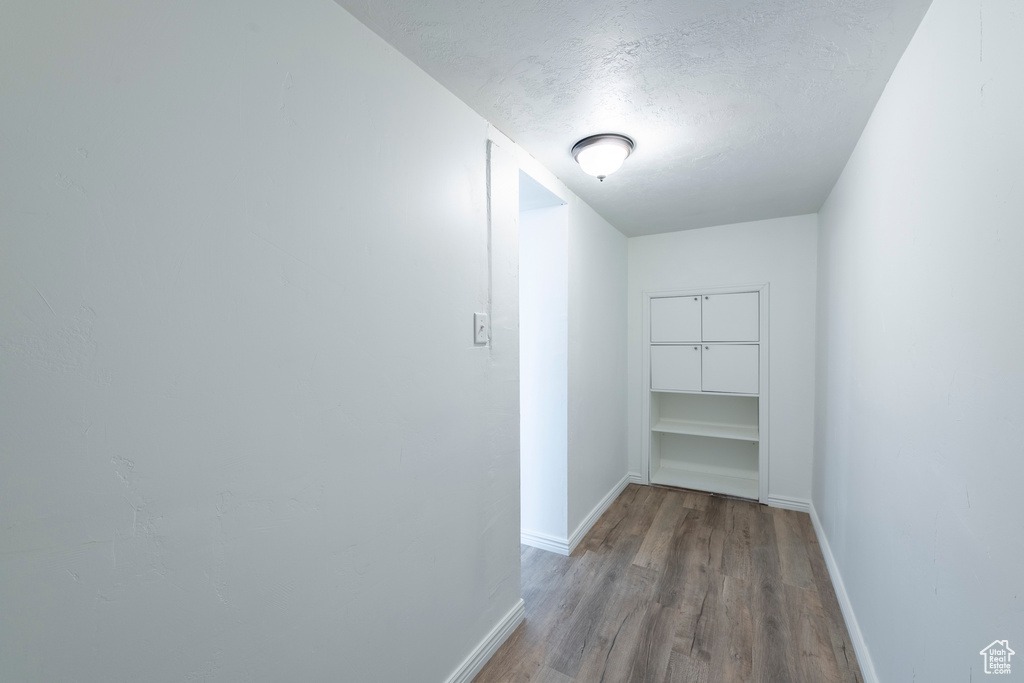 Corridor featuring a textured ceiling and light wood-type flooring