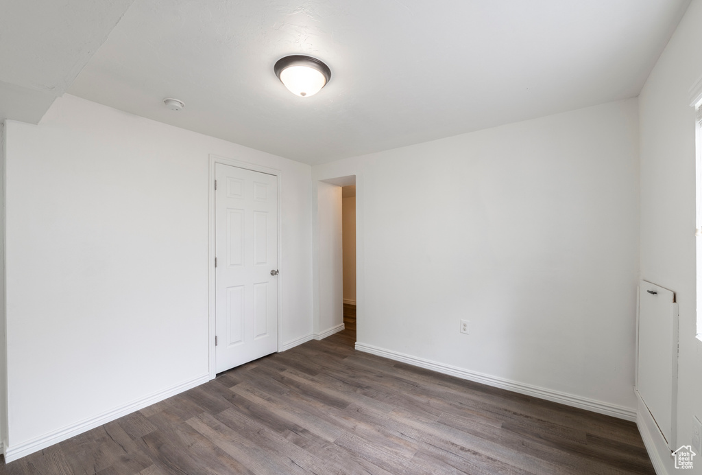 Unfurnished room with dark wood-type flooring