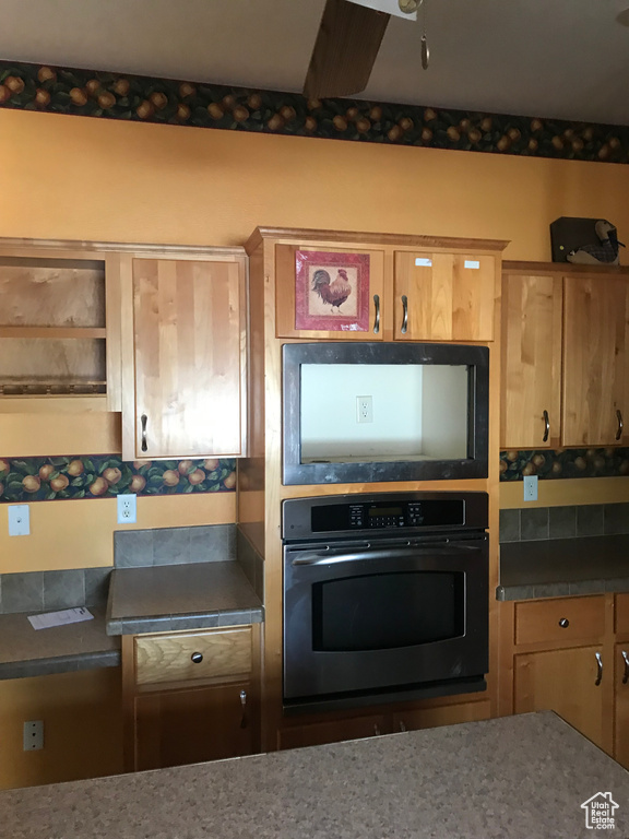 Kitchen featuring black oven and ceiling fan