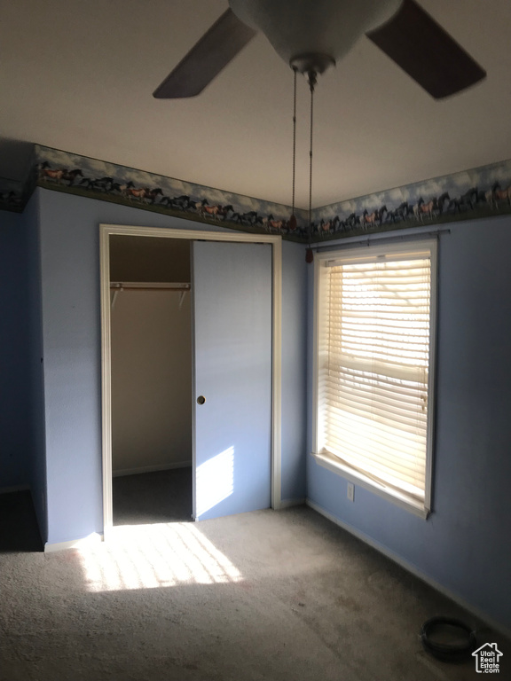 Unfurnished bedroom with a closet, carpet flooring, and ceiling fan