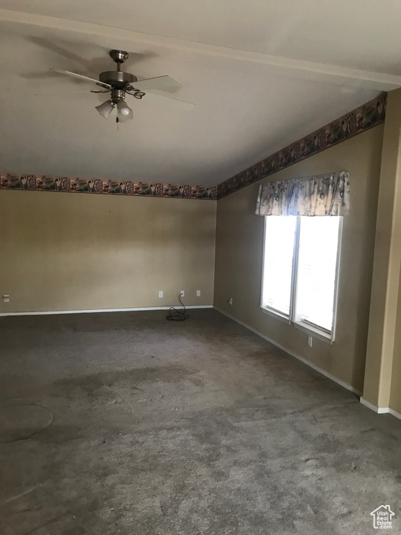 Unfurnished room with beamed ceiling, carpet flooring, and ceiling fan