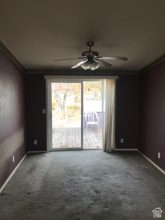 Carpeted empty room with a wealth of natural light and ceiling fan