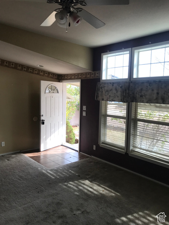 Carpeted entrance foyer with ceiling fan