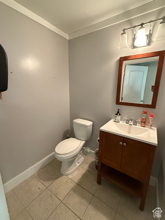 Bathroom featuring crown molding, toilet, vanity, and tile patterned floors