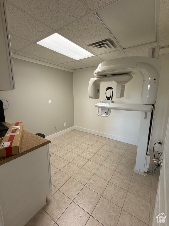 Interior space with light tile patterned floors and a drop ceiling