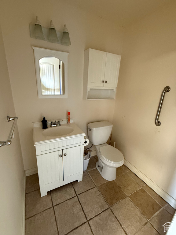 Bathroom featuring toilet, vanity, and tile patterned floors