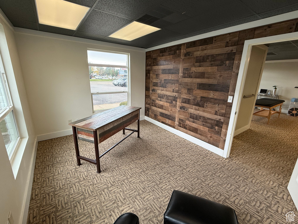 Home office with wood walls and a drop ceiling