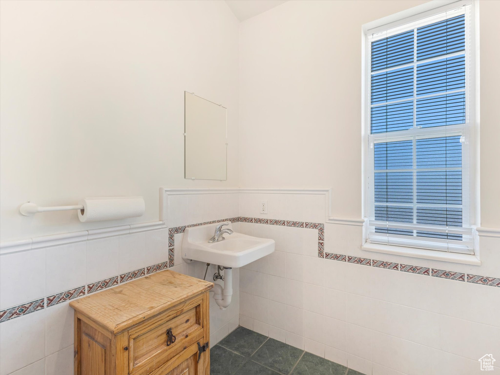 Bathroom featuring tile walls, sink, and tile patterned floors