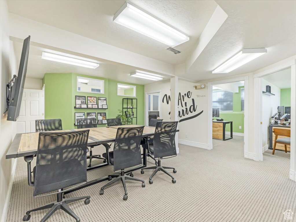 Home office featuring a textured ceiling and light carpet