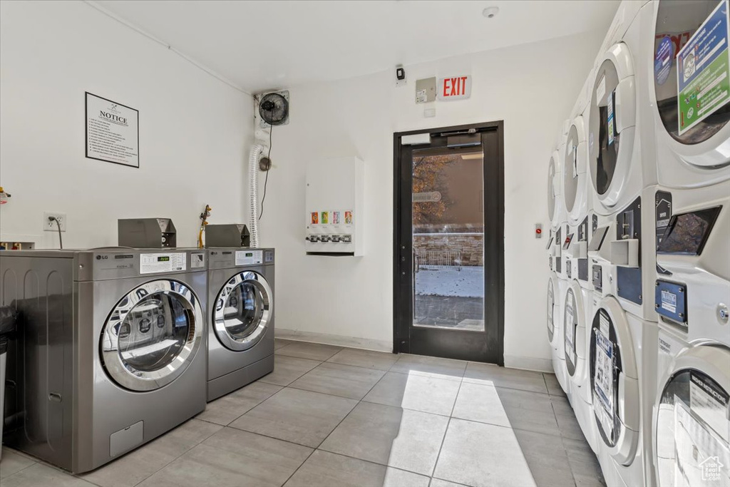 Laundry area featuring light tile patterned floors, washing machine and dryer, and stacked washer / dryer