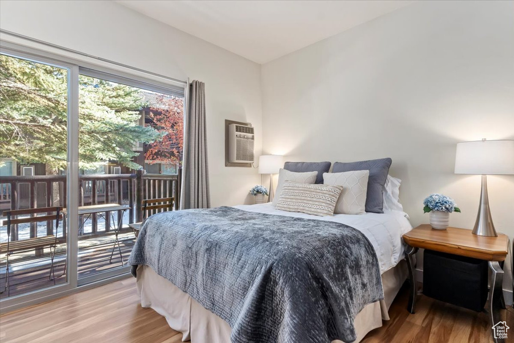 Bedroom featuring a wall unit AC and hardwood / wood-style floors