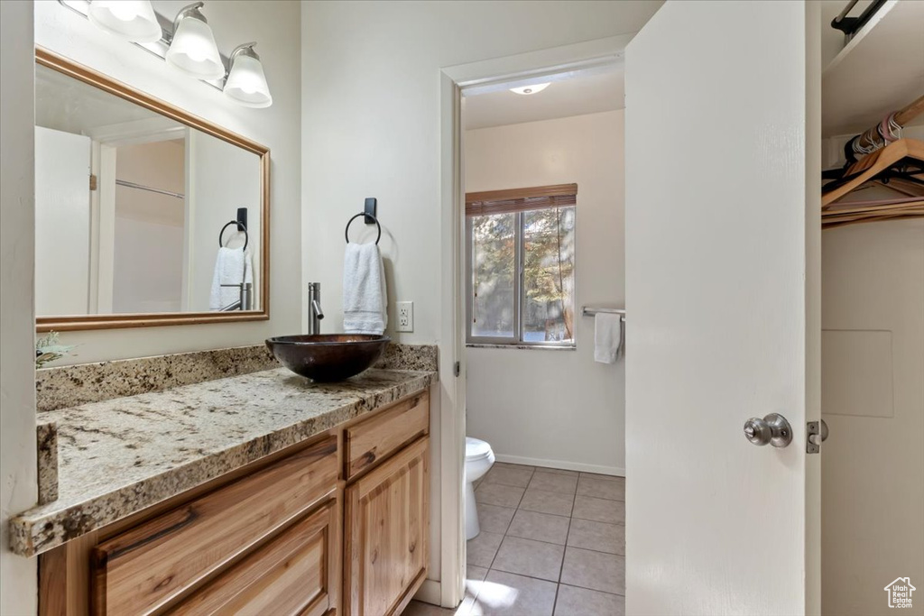 Bathroom with toilet, vanity, and tile patterned flooring