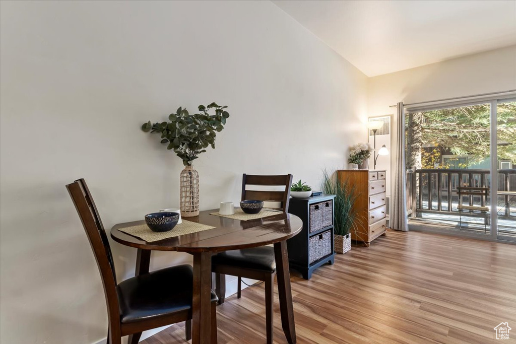 Dining room featuring light wood-type flooring and vaulted ceiling