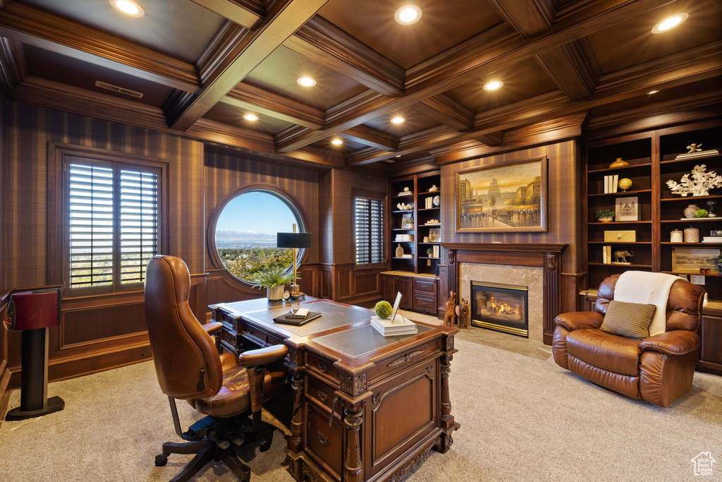 Office with light colored carpet, wooden walls, built in shelves, and coffered ceiling