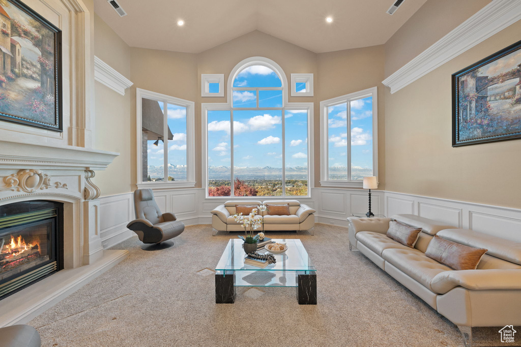 Carpeted living room featuring a high ceiling and a high end fireplace